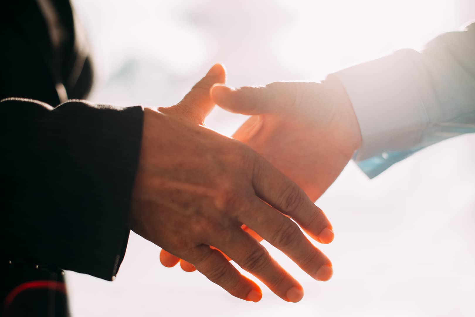 Two people shaking hands in agreement regarding their estate planning documents.